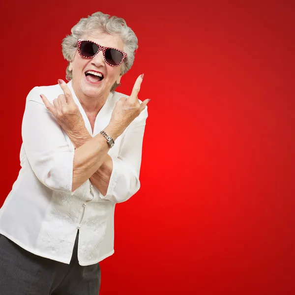 Senior vrouw dragen van een zonnebril doet funky actie — Stockfoto