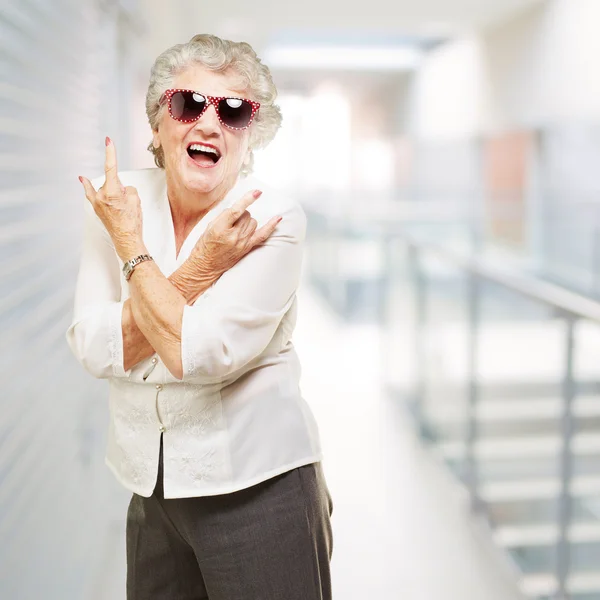 Retrato de mujer mayor sonriendo y usando gafas de sol en moder —  Fotos de Stock