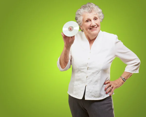 Äldre kvinna anläggning cd — Stockfoto
