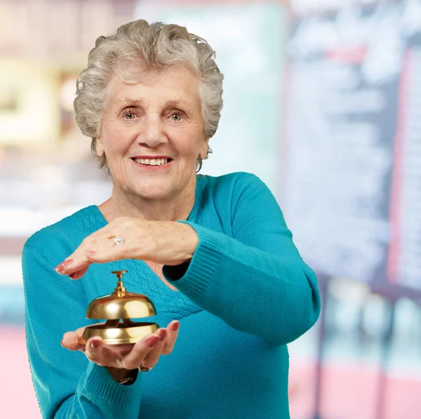 Feliz mujer madura mientras sostiene la campana — Foto de Stock