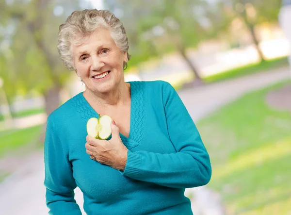 Portret szczęśliwy starsza kobieta trzymając jabłko — Zdjęcie stockowe