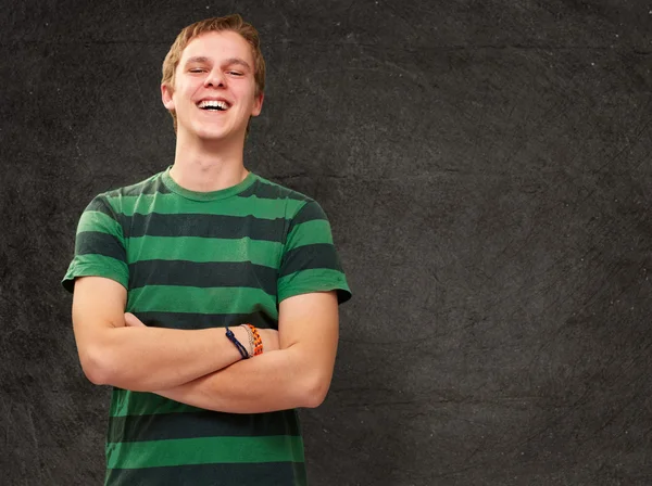 Portrait de jeune homme souriant contre un mur grognant — Photo