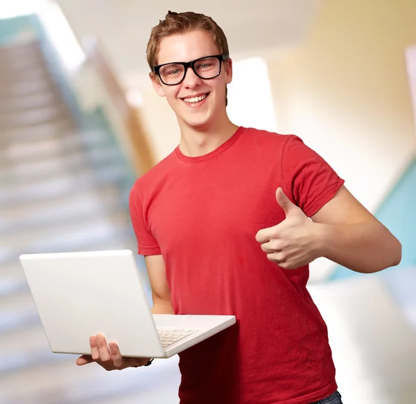 Mann hält Laptop mit erhobenem Daumen — Stockfoto