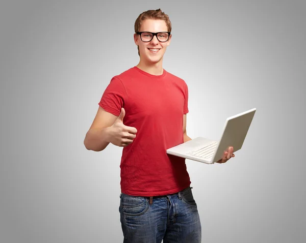 Чоловік тримає ноутбук з великими пальцями вгору — стокове фото