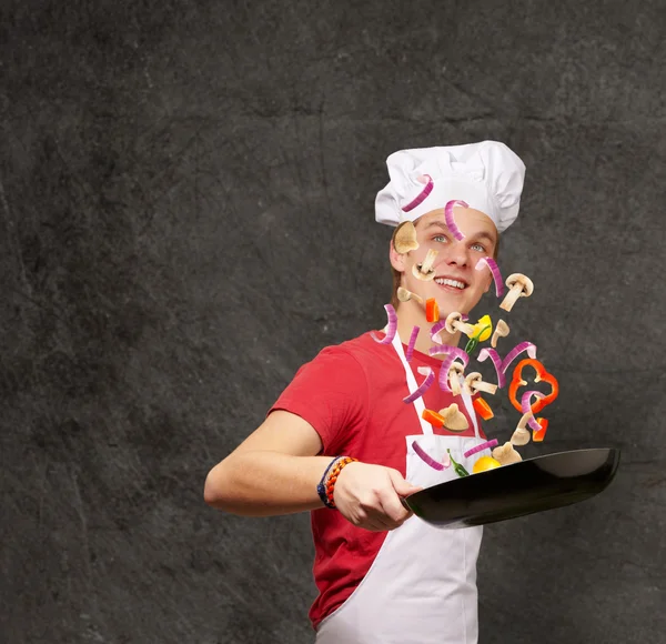 Grunge w karşı sebze yemek genç aşçı adam portresi — Stok fotoğraf