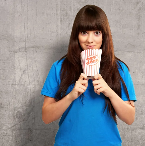 Portrait of a girl holding empty popcorn packet — Stock Photo, Image