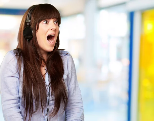Mujer sorprendida usando auriculares — Foto de Stock