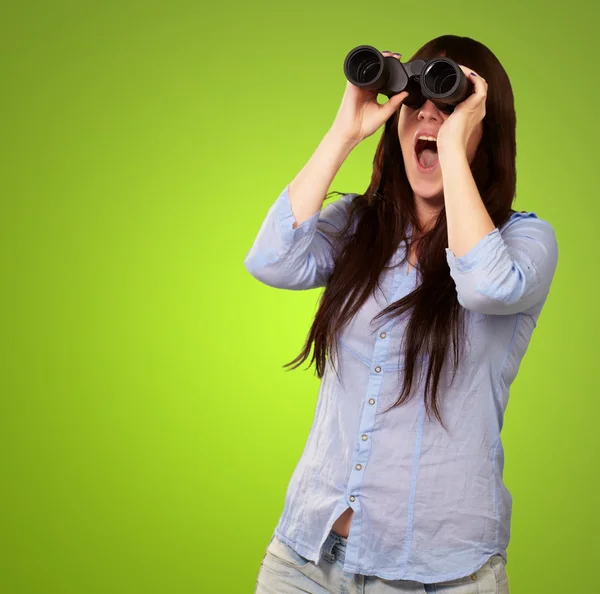 Porträt einer jungen Frau, die durch ein Fernglas blickt — Stockfoto