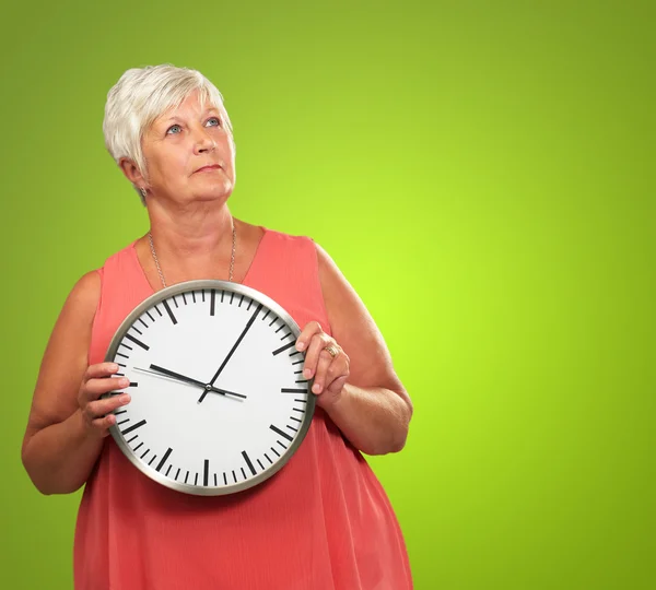 Mujer mayor sosteniendo un reloj — Foto de Stock