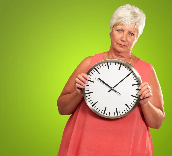 Mujer mayor sosteniendo un reloj — Foto de Stock