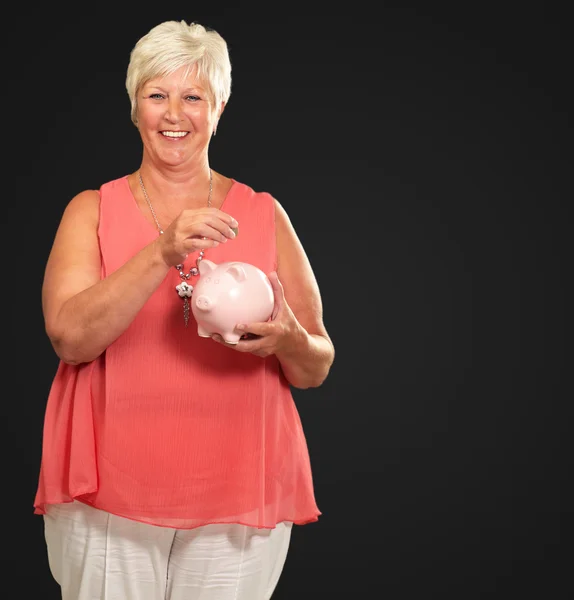 Sênior mulher segurando um piggybank — Fotografia de Stock