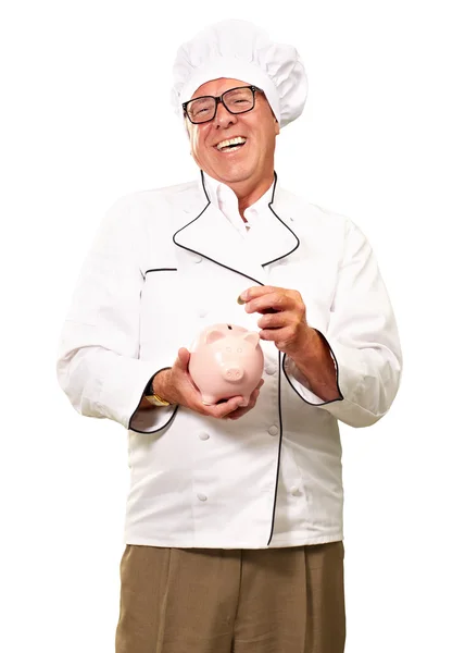 Chef poniendo monedas en Piggybank — Foto de Stock