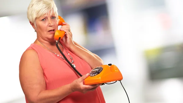 Ritratto di una donna anziana con un telefono retrò — Foto Stock