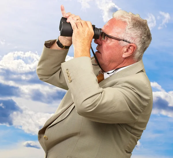 Uomo anziano guardando attraverso binocoli — Foto Stock