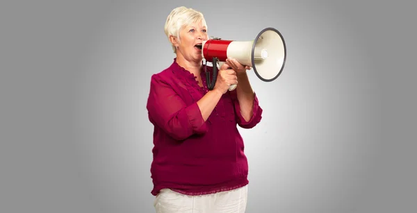 Портрет пожилой женщины с мегафоном — стоковое фото