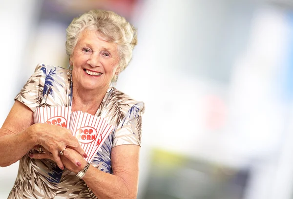 Portret van een senior vrouw met popcorn vak — Stockfoto