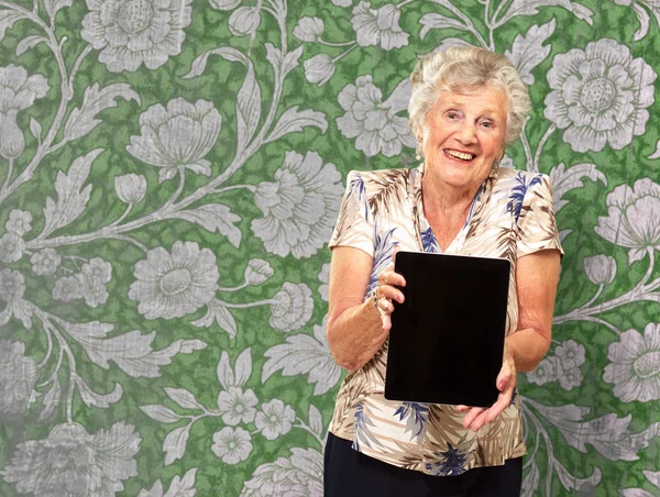 Retrato de uma mulher sênior segurando um tablet digital — Fotografia de Stock