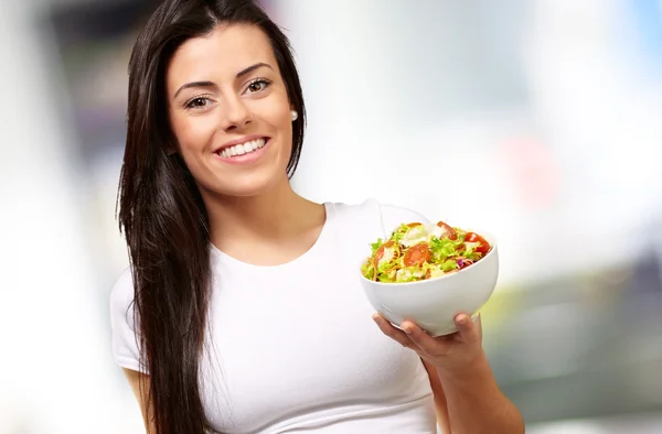 Chica joven mostrando un tazón de ensalada — Foto de Stock