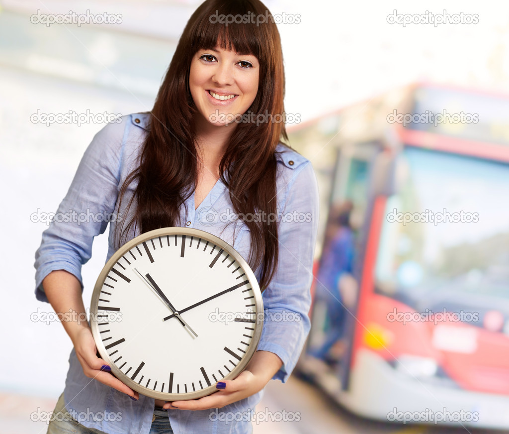 A Young Girl Holding A Clock