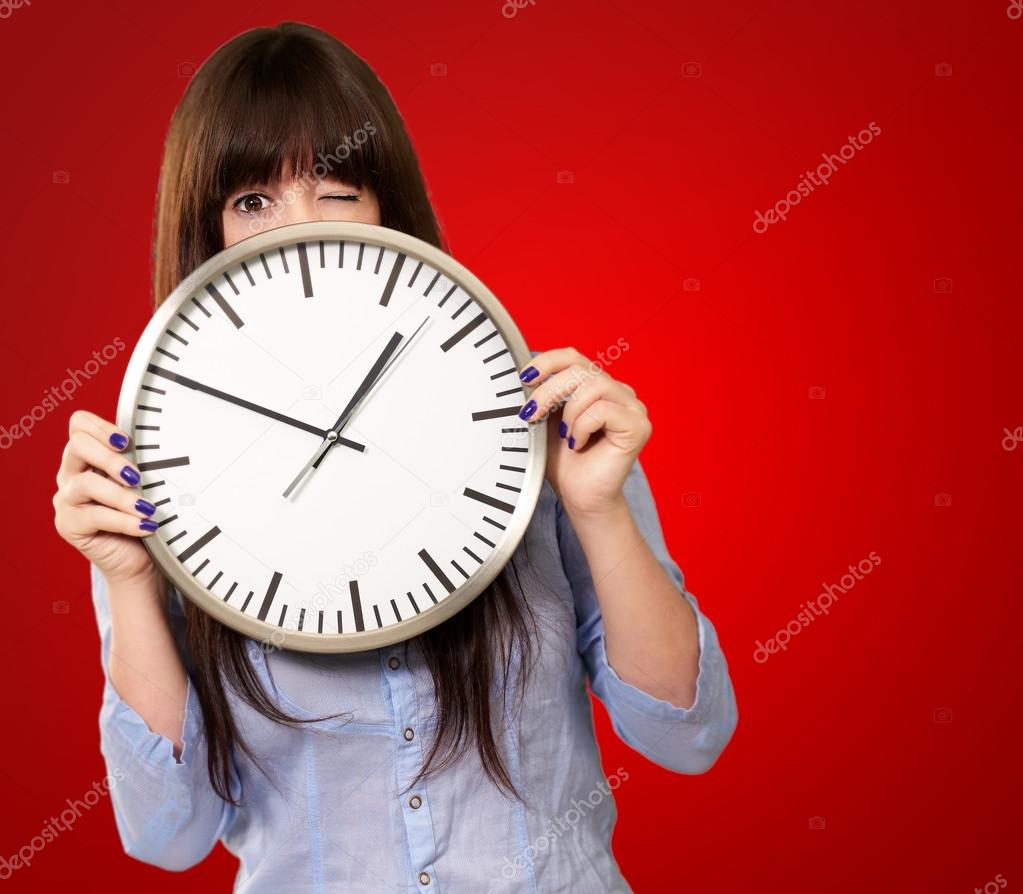 Woman Holding Clock Winking