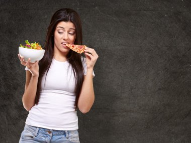 pizza yemek ve salata karşı arayan genç bir kadın portresi bir