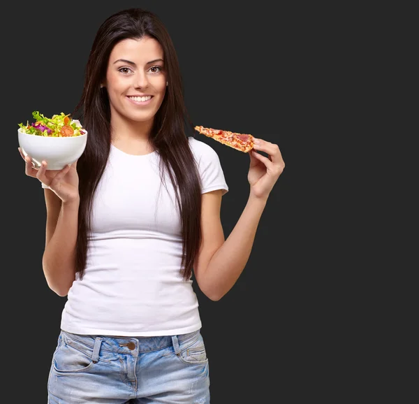 Feminino segurando um pedaço de pizza e saladeira — Fotografia de Stock