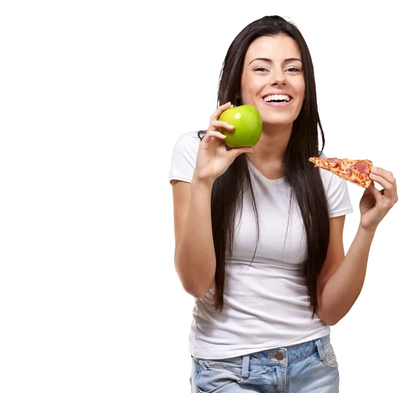 Kvinna håller en bit pizza och ett äpple — Stockfoto