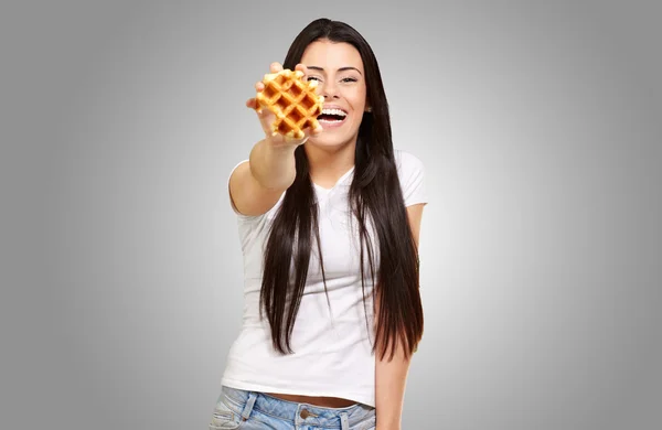 Une jeune femme tenant et montrant à gaufre — Photo