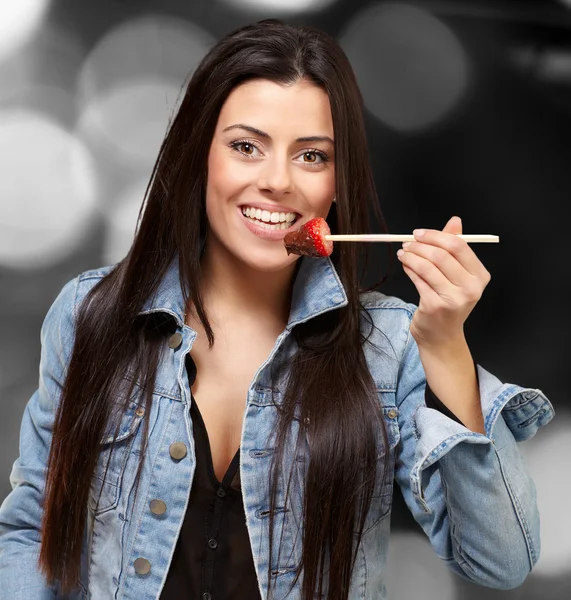 Retrato de uma fêmea comendo morango com molho de chocolate — Fotografia de Stock