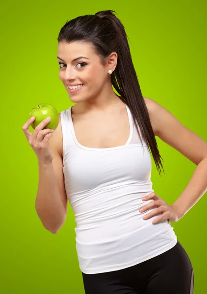 Mujer joven sosteniendo y comiendo una manzana — Foto de Stock