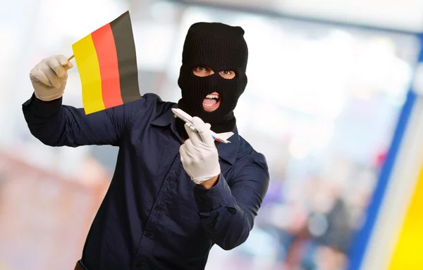 Man bär en rånare mask och hålla flygplan miniatyr och FLA- — Stockfoto