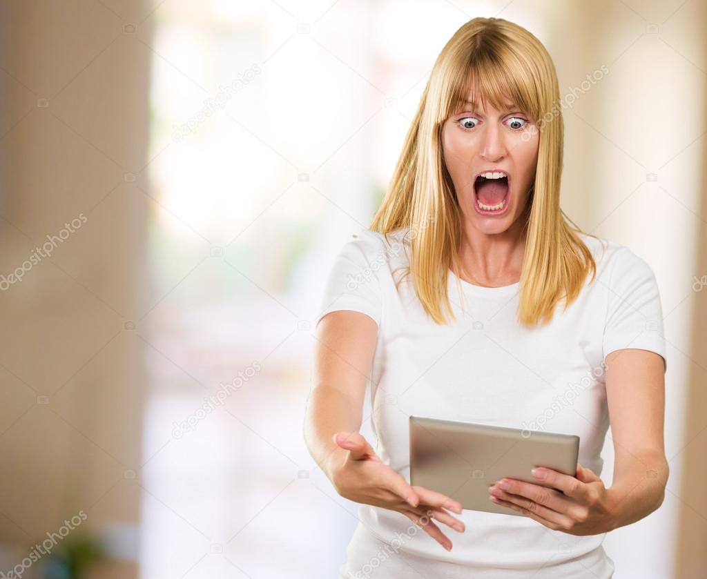 Shocked Woman Looking At Digital Tablet