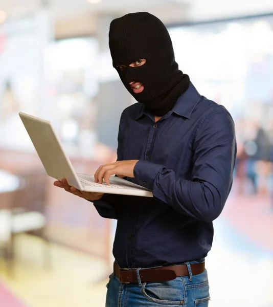 Genç erkek hırsız holding laptop — Stok fotoğraf