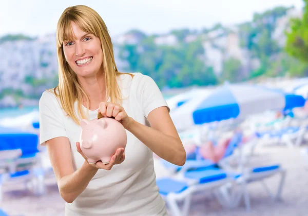 Vrouw munt invoegen in spaarpot — Stockfoto
