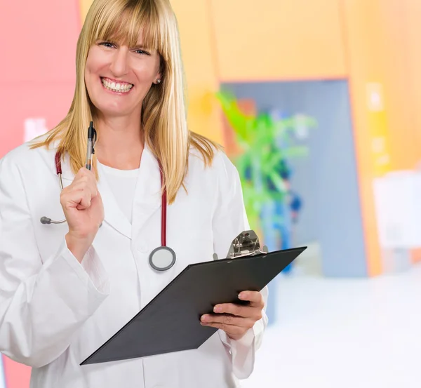 Feliz médico femenino sosteniendo un portapapeles —  Fotos de Stock