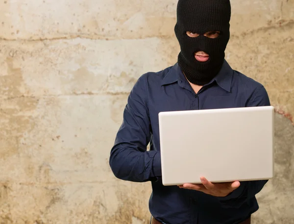 Junger männlicher Dieb mit Laptop — Stockfoto