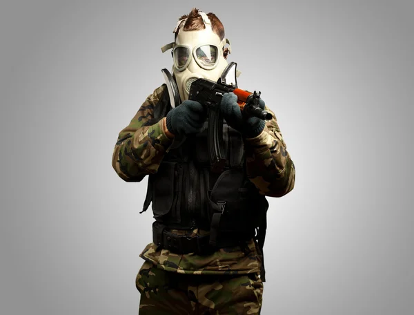 Porträtt av en soldat med gasmask sikta med pistol — Stockfoto