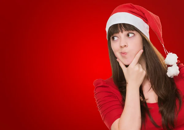 Woman thinking and wearing a christmas hat — Stock Photo, Image