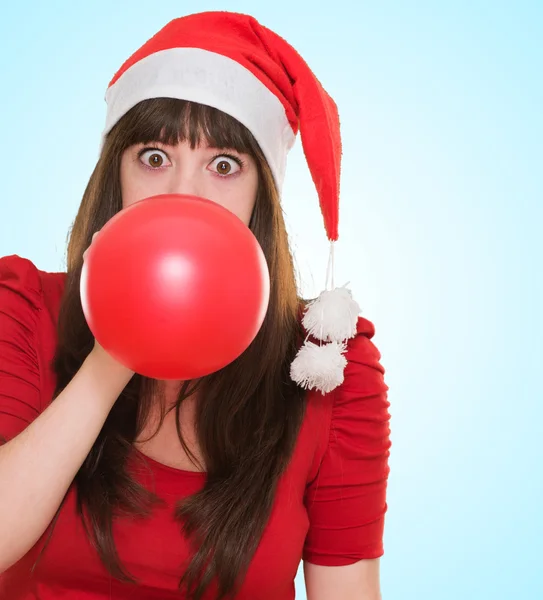 Vrouw opblazen van de ballon en dragen een kerstmuts — Stockfoto