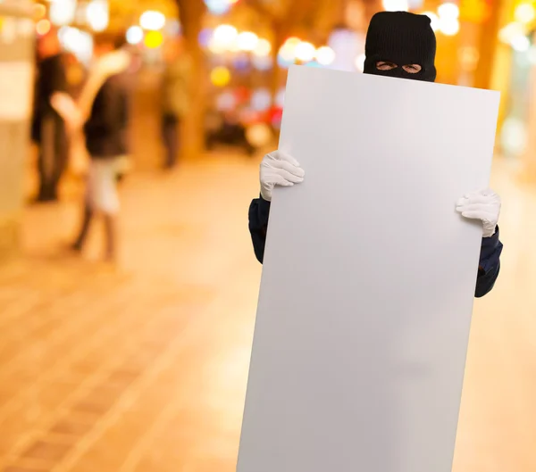 Retrato de un hombre con máscara sosteniendo la tarjeta en blanco —  Fotos de Stock