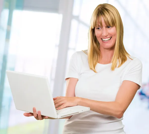 Donna felice guardando il computer portatile — Foto Stock