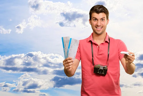 Man holding boarding pass and airplane — Stock Photo, Image