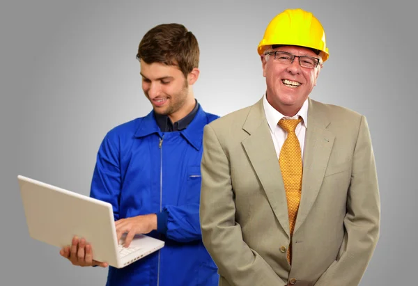 Engenheiros sorrindo na frente do arquiteto usando laptop — Fotografia de Stock