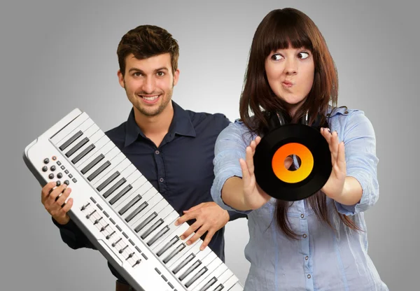 Young Girl Showing Vinyl Against Young Man Holding Piano — Stock Photo, Image