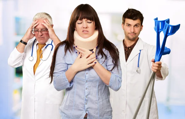 Mujer con corsé en el cuello delante de los médicos —  Fotos de Stock