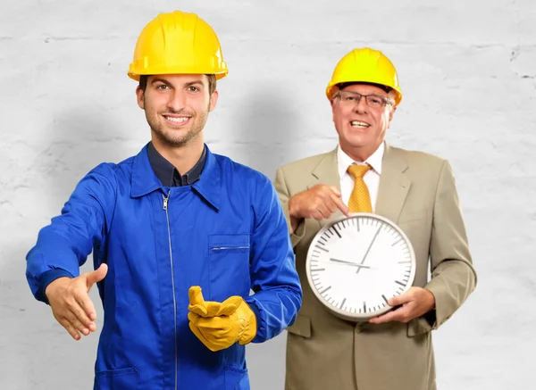 Arquitecto Gestos en frente de Ingeniero Holding Clock — Foto de Stock