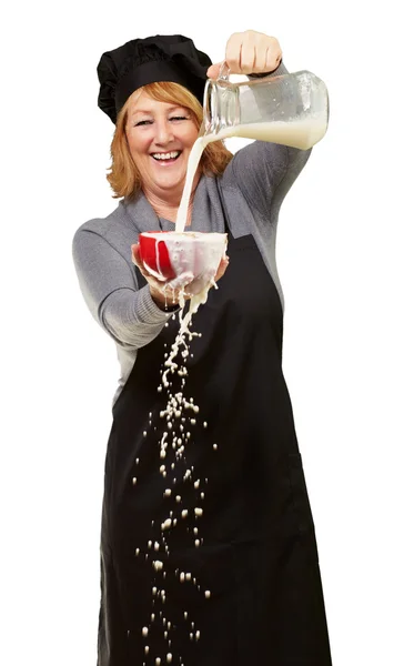 Portrait of a woman pouring milk — Stock Photo, Image