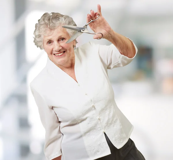 Seniorin hält Schere in der Hand — Stockfoto