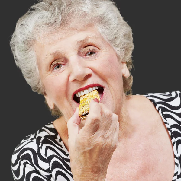 Portrait of a woman eating granola bar — Stock Photo, Image