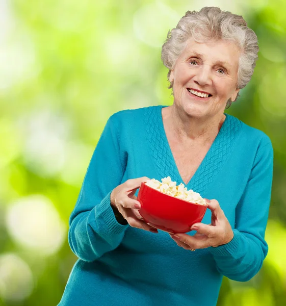 Starší žena hospodářství popcorn — Stock fotografie